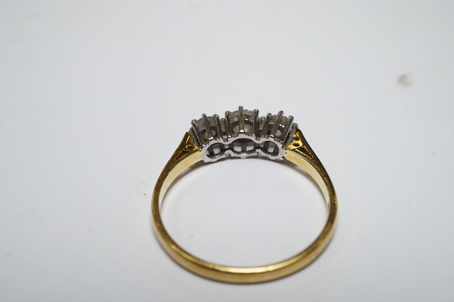 A modern 18ct gold and three stone diamond set ring, size M, gross weight 2.1 grams. Condition - fair to good